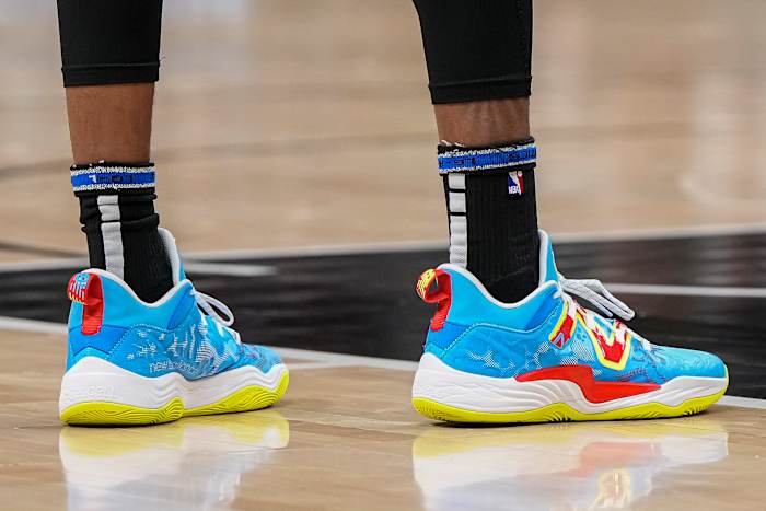 View of blue, yellow, and red New Balance shoes.